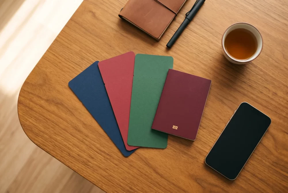 複数の航空会社の航空券とパスポート・手帳・焙じ茶のフラットレイ