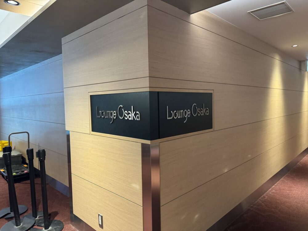 伊丹空港 (大阪国際空港) 中央ブロック3階にあるカードラウンジ Lounge Osaka のエントランス、木目調パネルにロゴ表示