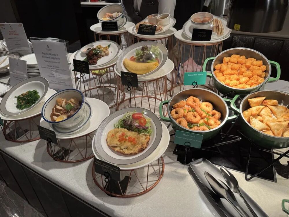 料理サンプルの展示。オムレツ、カヤトースト、サモサなどが並び、キッズメニューの案内も立つ