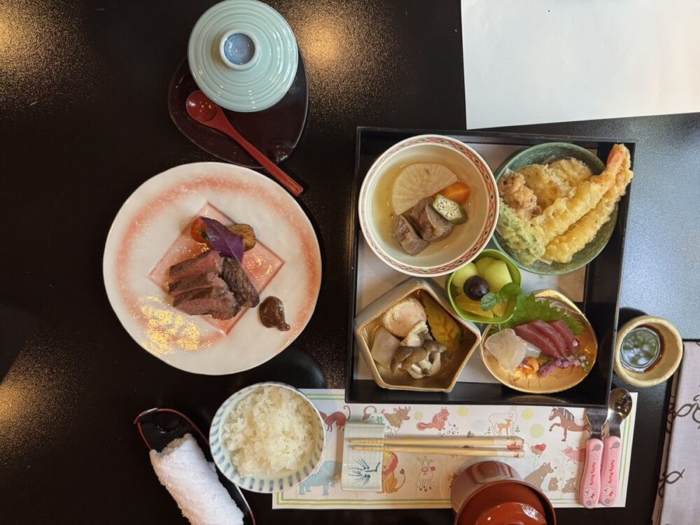 子ども向けに用意された懐石。ステーキ、天ぷら、刺身、煮物、果物が並ぶ
